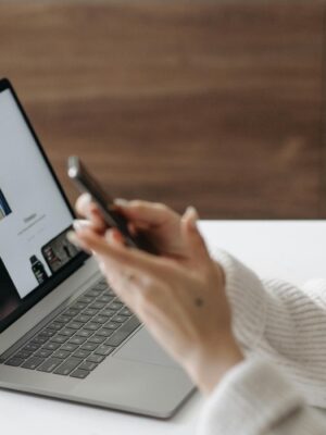 Asian woman shopping online with a laptop and smartphone at home.
